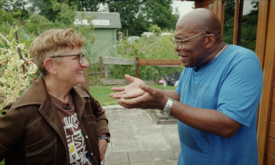 Een man en een vrouw in gesprek in een tuin