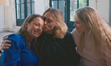 drie vrouwen geven elkaar een knuffel op de bank