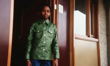 Meisje met groene jas in deuropening