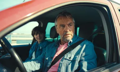 Man en kind in auto met gordel om