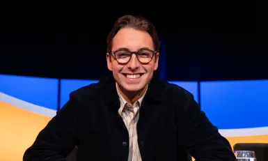 Jongen met bril en zwart vest in de studio