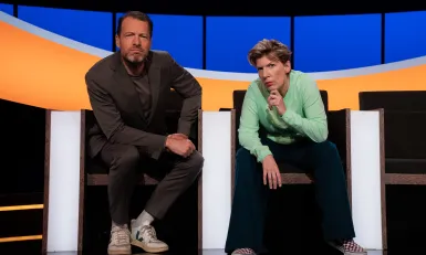 Man en vrouw in studio kijken serieus