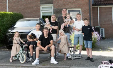 De familie De Lange uit Een huis vol poseert voor een huis