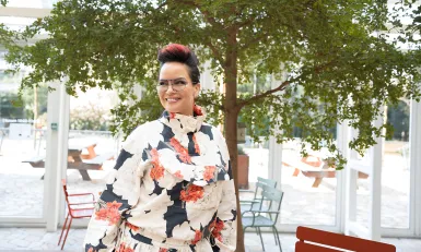 Mevrouw met bloemenprint shirt voor een boom