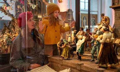 Meisje en vrouw kijken naar kerststal