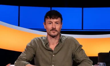 Man met donker haar en snor en groen overhemd