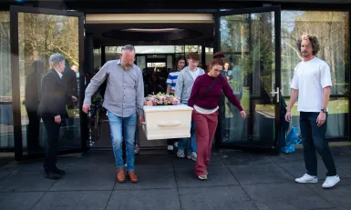 Iwan en Mara dragen de kist van hun zoon Job 