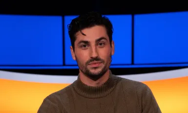 Man met zwart haar bruine coltrui 