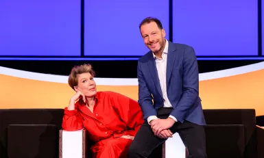 Man in blauw pak en vrouw in rood pak in studio