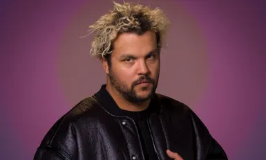 Man in zwarte jas kijkt serieus