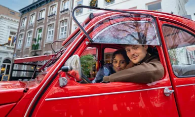 twee mensen in een rode auto