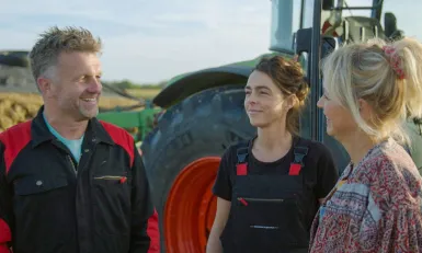 drie mensen voor een tractor