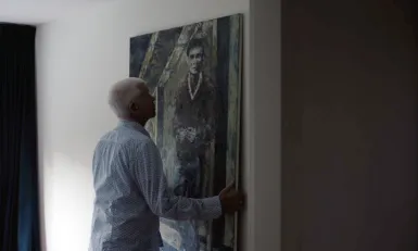 Man hangt schilderij op