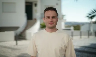 Man voor gebouw met palmbomen