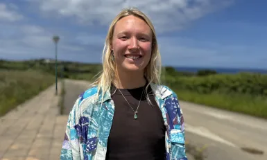 Vrouw in blauw jasje lachend naar camera
