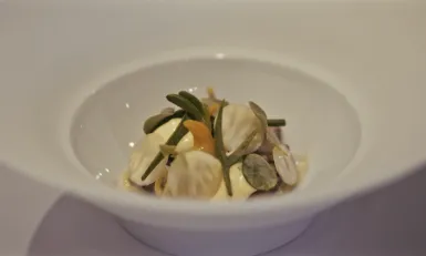 Bord met culinair gerecht met kokkels en lam