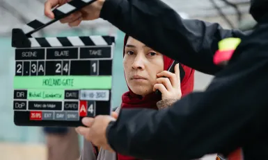 een achter de schermen foto van een vrouw die belt in docuserie Holland Gate