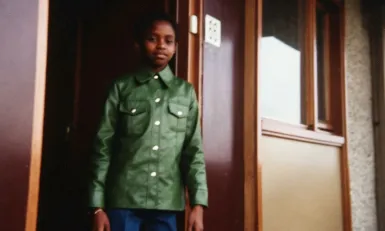 Meisje met groene jas in deuropening